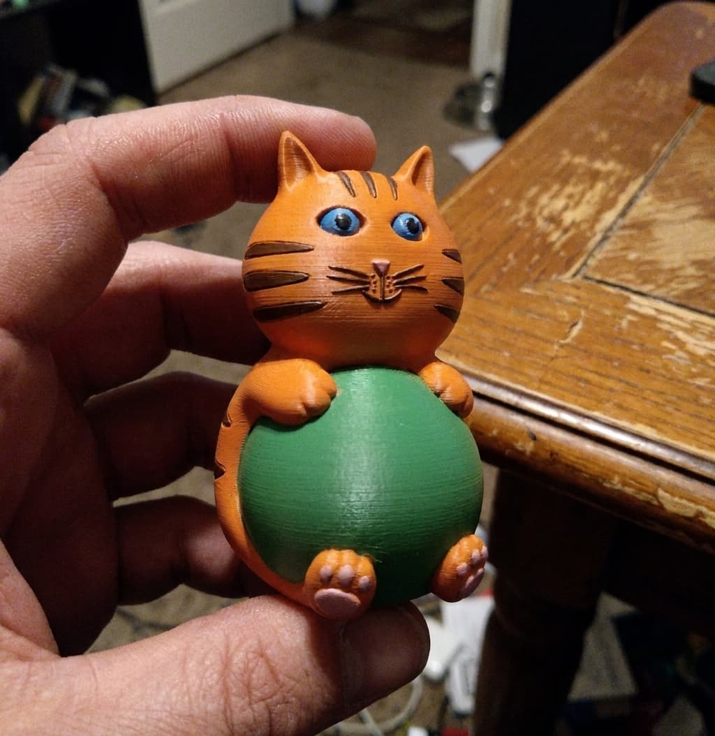 3D printed cat figurine held in a hand